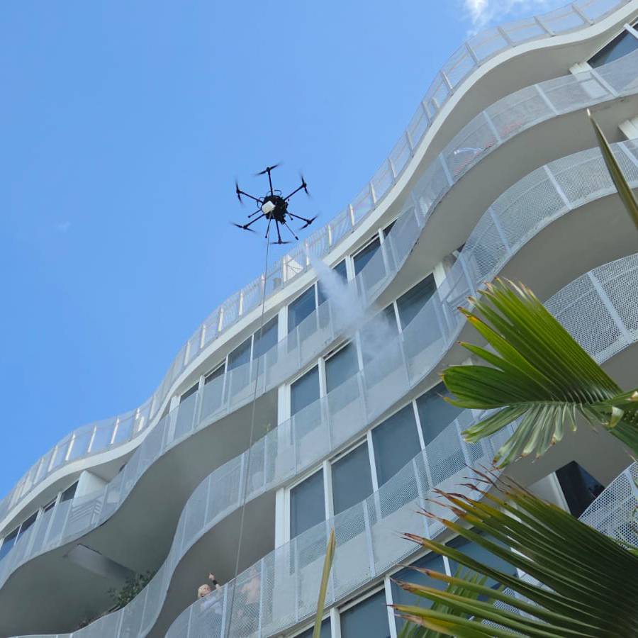 Drone reaching high estate glass above a Palm Beach pool terrace
